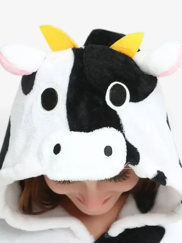 Close-up of the cow onesie hood featuring plush horns, ears, and a cute cow face.