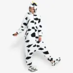 Woman modeling a comfortable adult cow onesie pajama costume.
