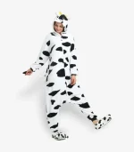 Woman modeling a comfortable adult cow onesie pajama costume.