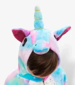 Close-up of a plush children's kigurumi hood detailing a soft blue horn, pink ears, and embroidered eyes.