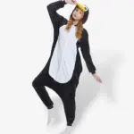 Person enjoying a playful moment wearing a warm, black and white Penguin Onesie For Adults.