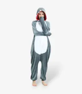 Woman smiling playfully with arms raised wearing the comfortable Shark Onesie For Adults.